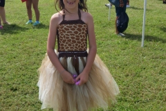Child dressed in a giraffe costume smiles during Cape Coral Kiwanis KidsFest 2025.