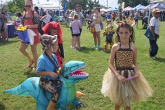 Children wearing dinosaur and giraffe costumes participate in Cape Coral Kiwanis KidsFest 2025.