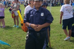 Child dressed as a police officer smiles at Cape Coral Kiwanis KidsFest 2025.