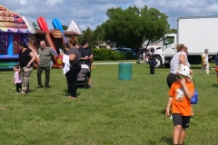 Families gather near inflatable attractions during Cape Coral Kiwanis KidsFest 2025.