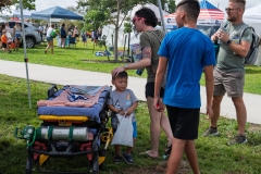 Child explores emergency medical equipment while families learn about EMS services at Cape Coral Kiwanis KidsFest 2025.