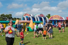 Families enjoy inflatable attractions including a corn maze and sports-themed activities during Cape Coral Kiwanis KidsFest 2025.