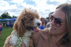 Woman holding a fluffy dog while attending Cape Coral Kiwanis KidsFest 2025.
