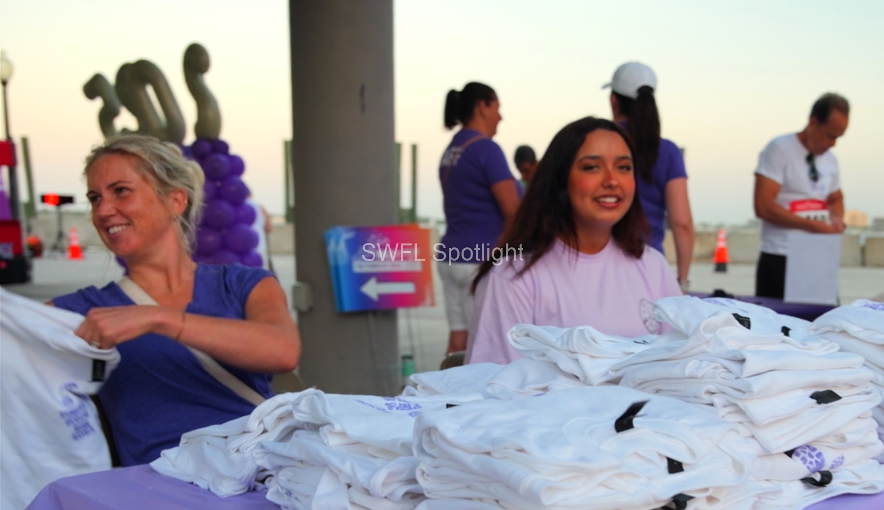 Volunteers distribute race shirts before the Purple Color Run at Centennial Park in Fort Myers.