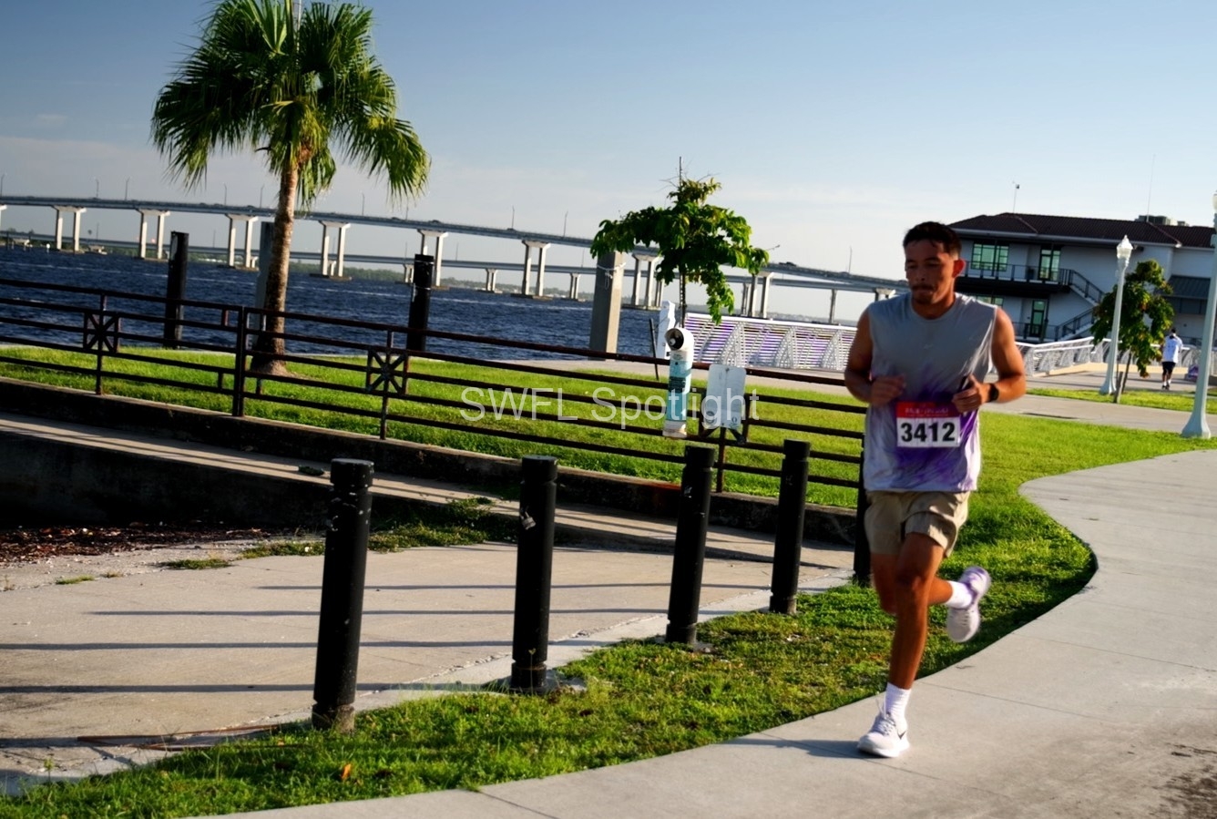 Runner follows the waterfront course near the Edison Bridge during the Purple Color Run in Fort Myers.