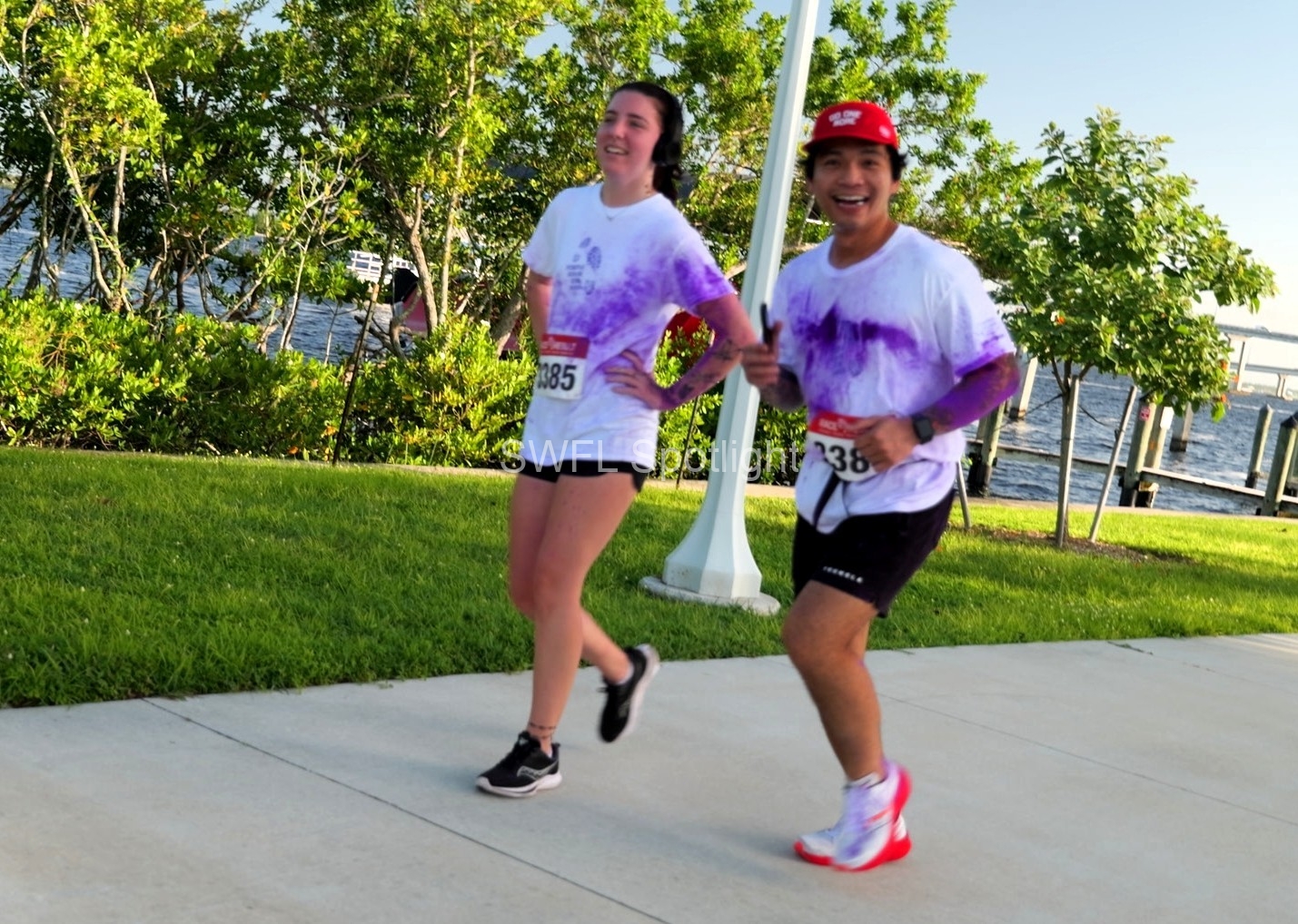 Purple Color Run participants smile while jogging the waterfront course in Fort Myers.