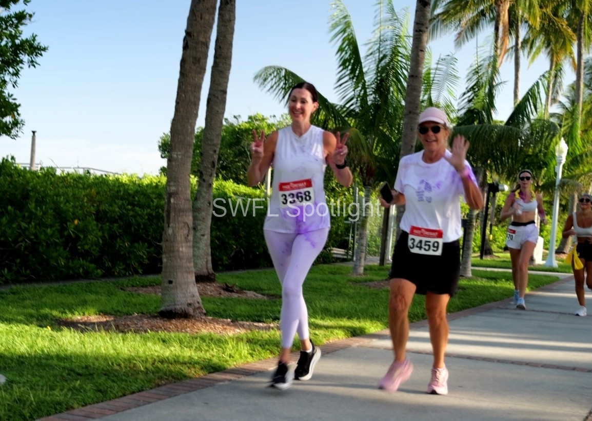 Participants wave while walking during the Purple Color Run in Downtown Fort Myers.