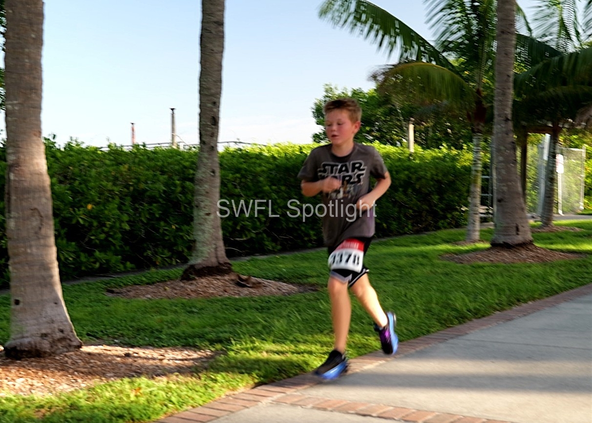 Young participant runs during the Purple Color Run in Downtown Fort Myers.