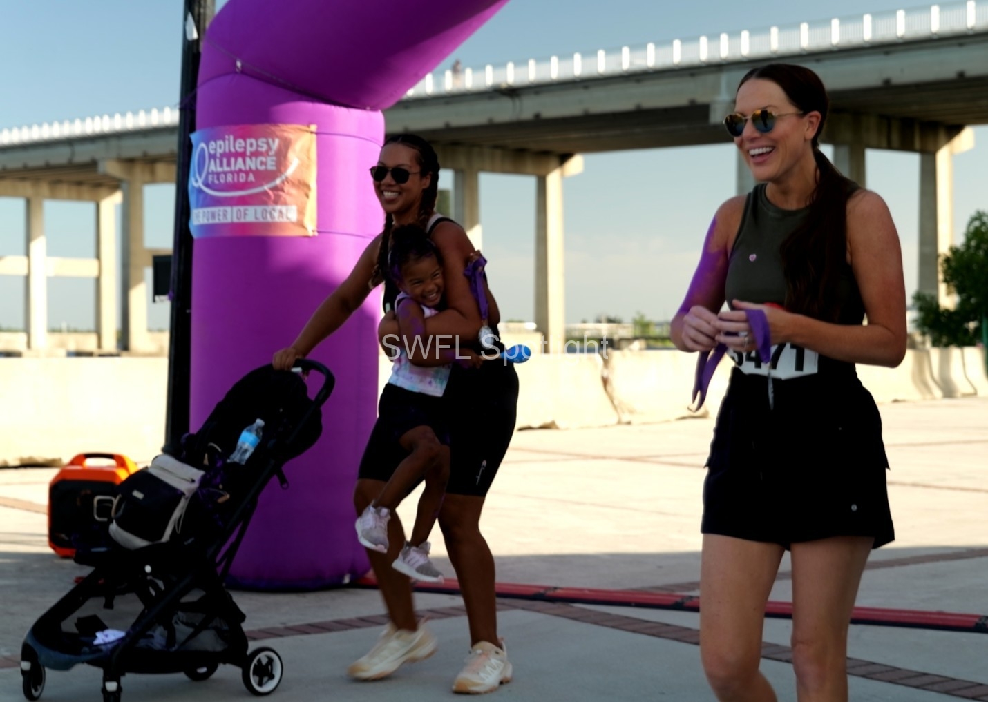 Families celebrate after crossing the finish line at the Purple Color Run in Fort Myers.