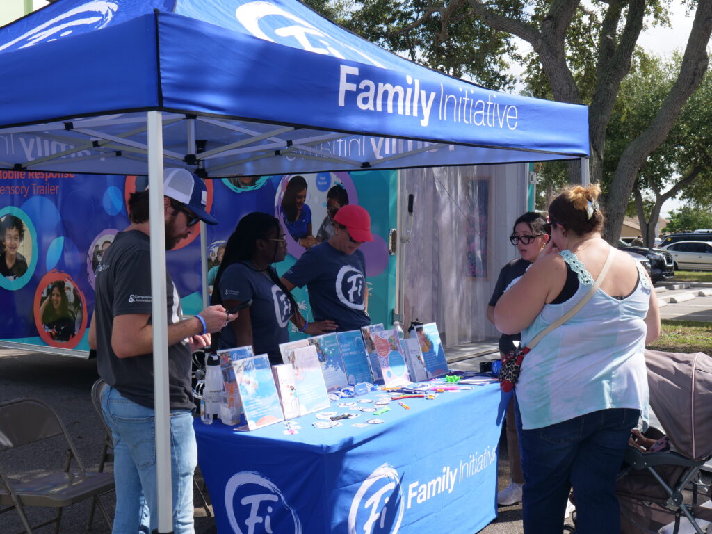 Families speak with volunteers at a Family Initiative booth during KidsFest in Cape Coral.