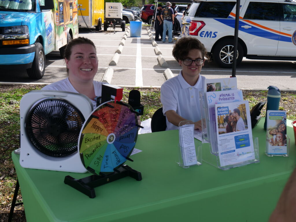 Volunteers at a community outreach booth share resources and information with families at KidsFest in Cape Coral.