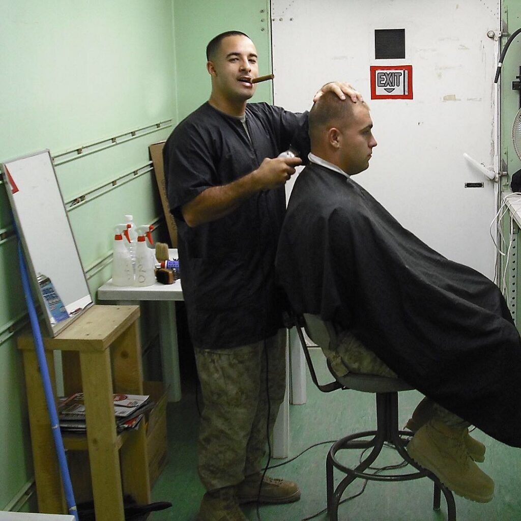 Nick Romero gives a haircut during his military service.