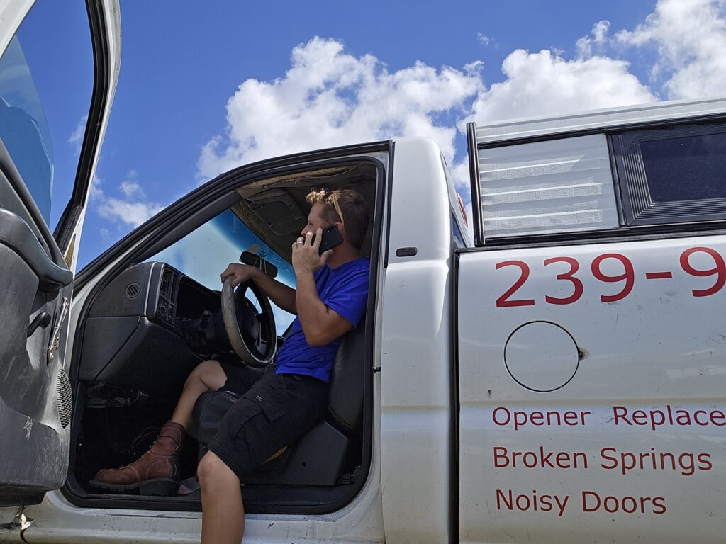 Safe Family Garage Door Repair service technician working by phone